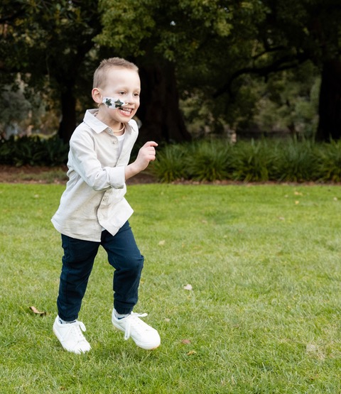 Ruben running joyfully outside on the grass